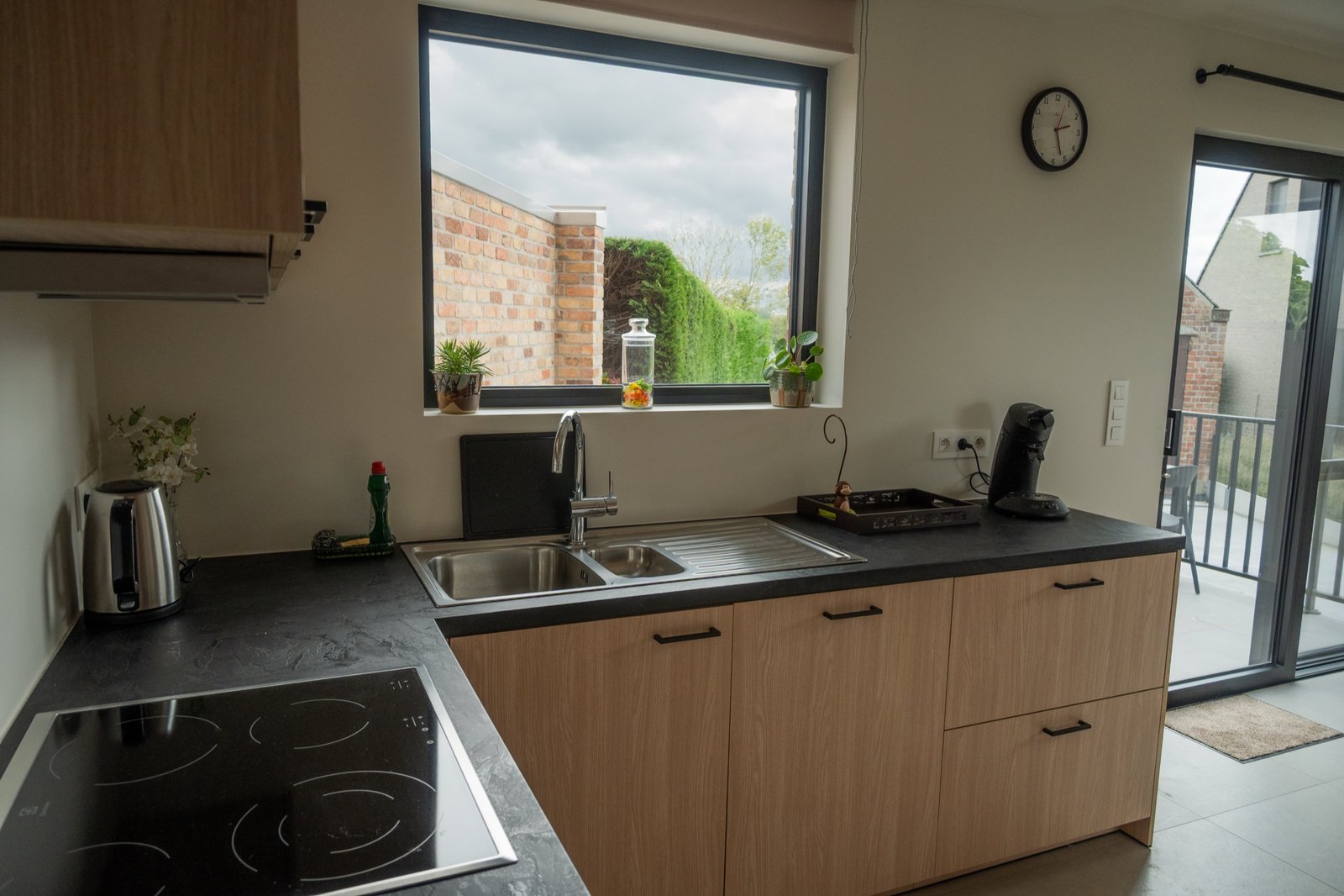 Keuken met vaatwas, oven en zicht op de tuin