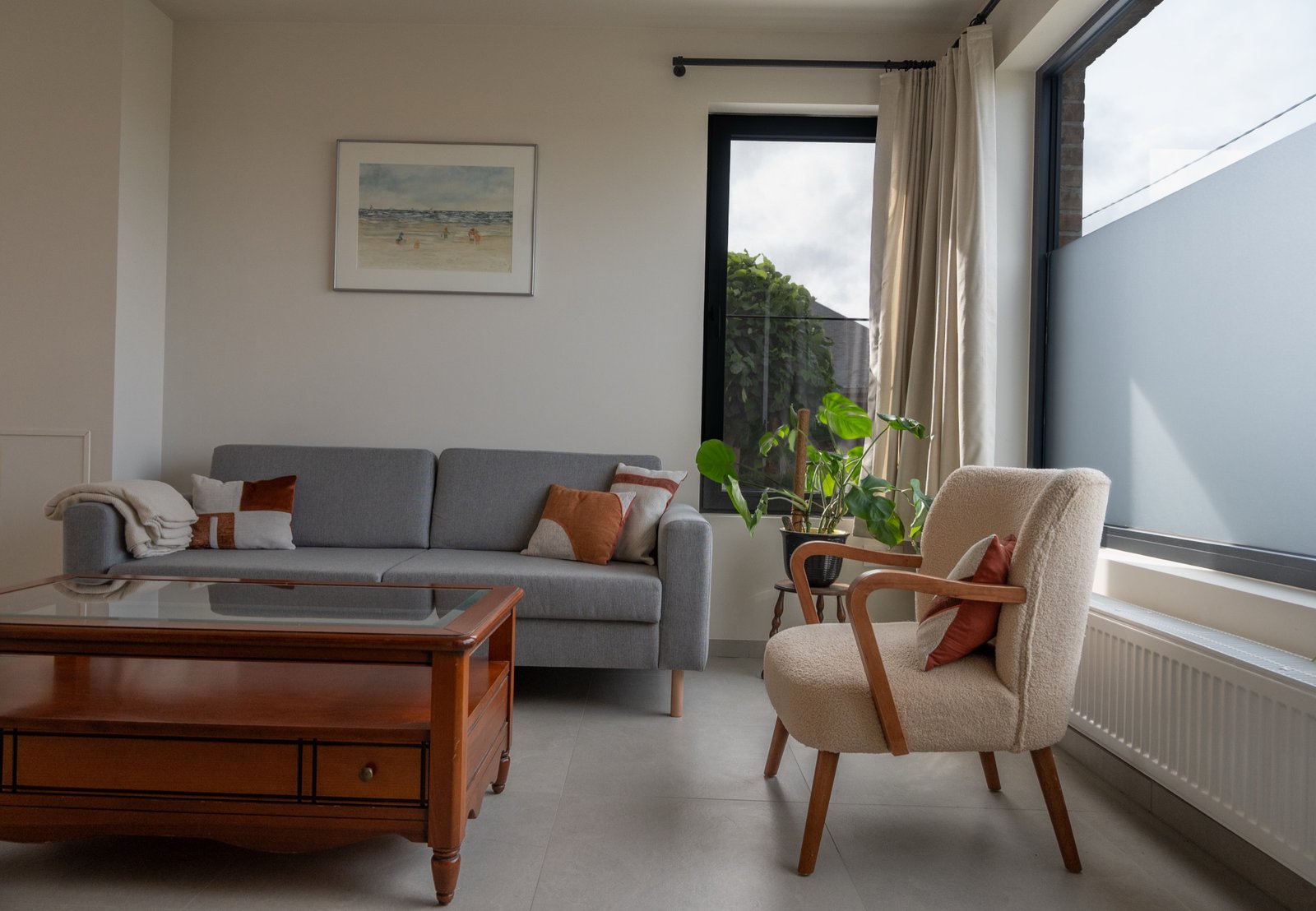 Woonkamer met zetel, salontafel en grote ramen